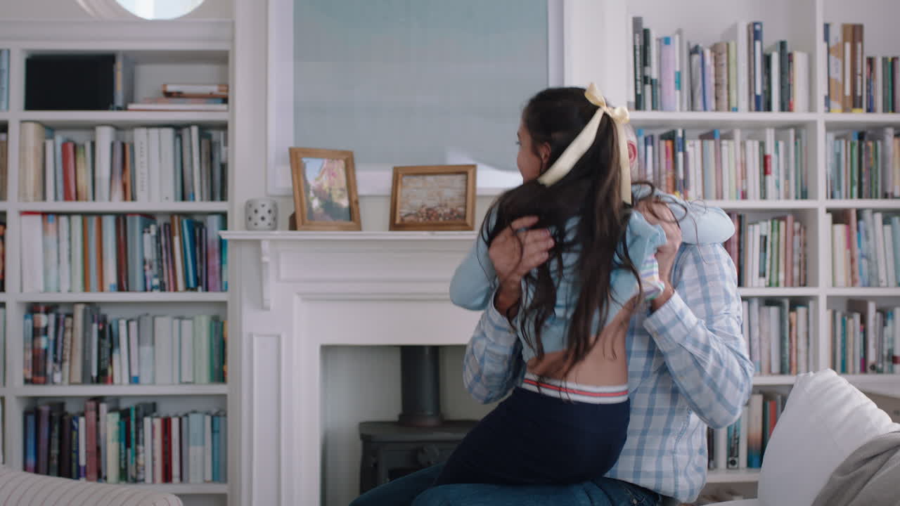 happy little girl hugging grandfather playfully jumping into grandad's arms having fun enjoying weekend with grandparent at home