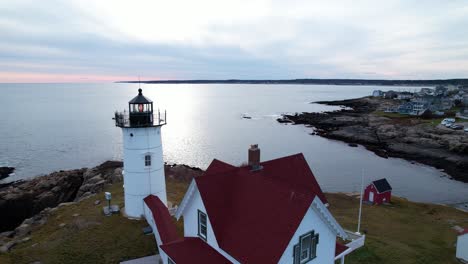 órbita-De-Un-Faro-En-Una-Isla-Rocosa-Con-Aguas-Reflectantes-En-El-Fondo