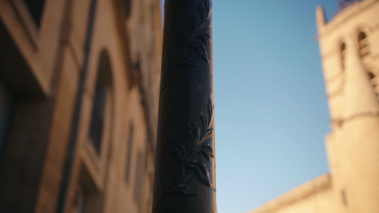 Lampione in primo piano con il campanile della chiesa sfocato sullo sfondo.