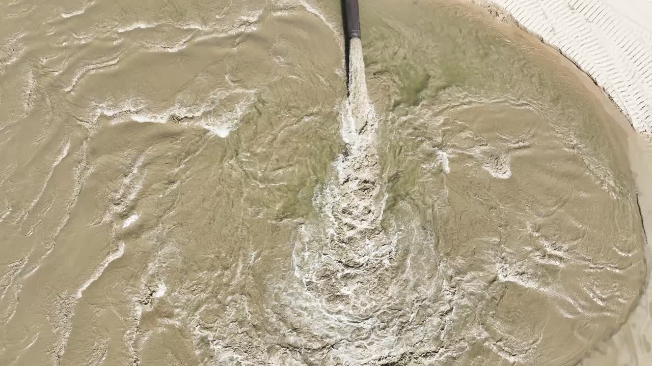 Water rushing across freshly laid sand