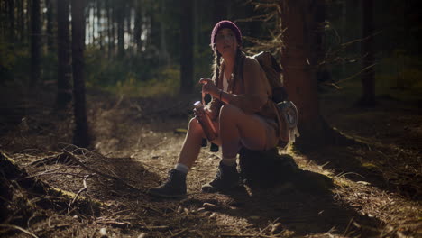 female explore resting while sitting on rock in forest