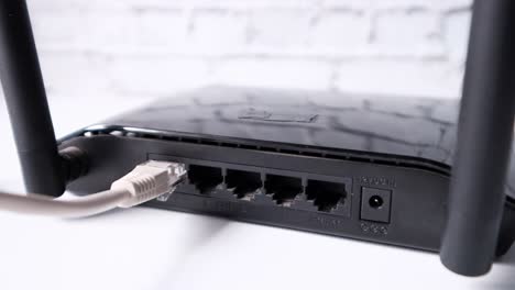 black wireless router with ethernet cable