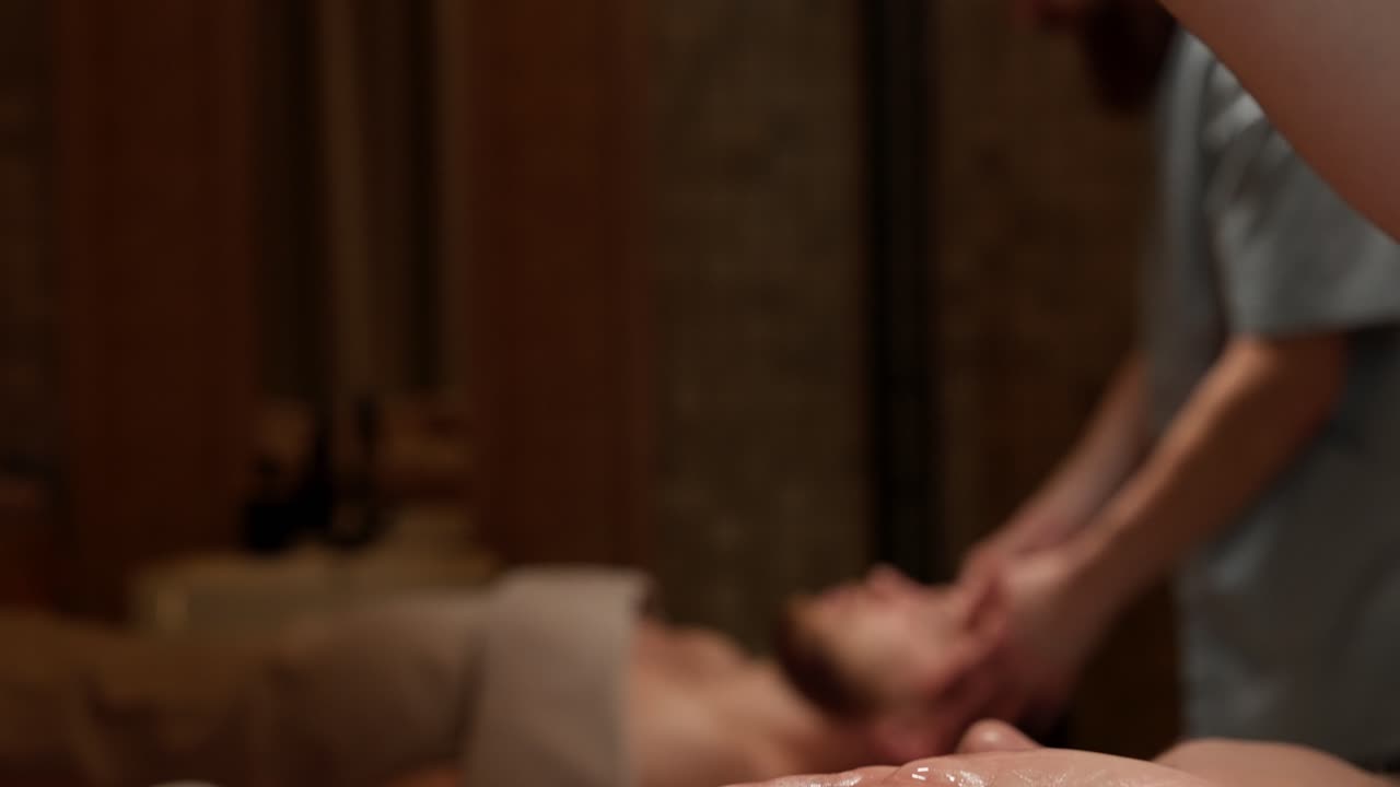 Nærbillede af massageolie, der hældes i hænderne på en spa