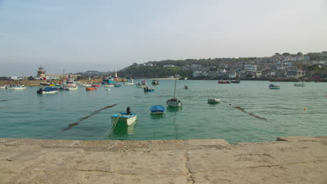 Barcos-Amarrados-En-Tranquilas-Aguas-Turquesas-En-El-Puerto-De-St-Ives-Durante-El-Día-En-Cornwall,-Suroeste,-Reino-Unido