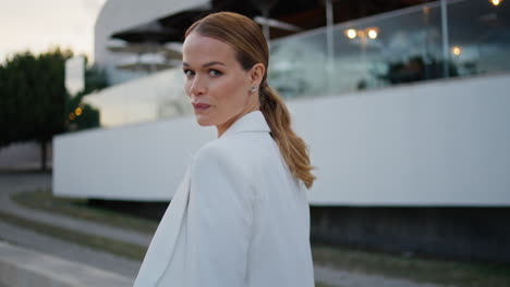 rich businesswoman walking evening town looking camera with smile close up.