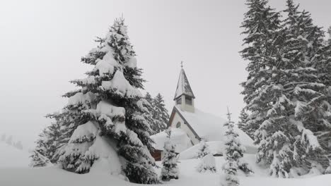 Capilla-Cubierta-De-Nieve-Rodeada-De-árboles,-Tiro-Panorámico-De-Gran-Angular