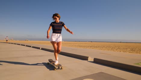 casual woman longboarding on desert background riding skateboard