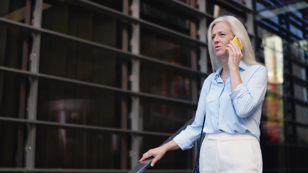 Woman talking on phone in front of office building