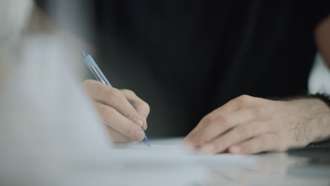 estudiante escribiendo con un bolígrafo en un cuaderno. primer plano de un hombre de negocios escribiendo con un bolígrafo