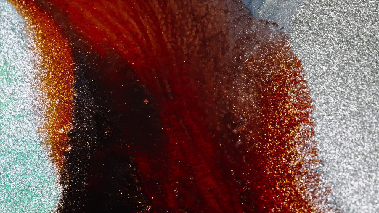 un primer plano de un líquido rojo y dorado giratorio con textura brillante, evocando misterio