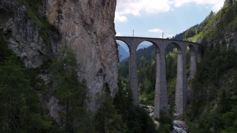 tilt up drone shot of the famous landwasser viaduct flyover in canton graubunden in the alps