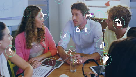 animation of ecology icons over diverse colleagues at meeting in office