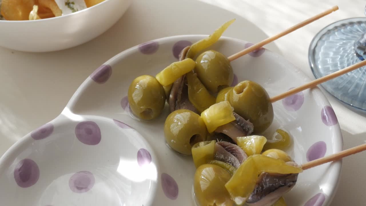 A plate with skewered olives, boquerones, and peppers, a popular tapas dish