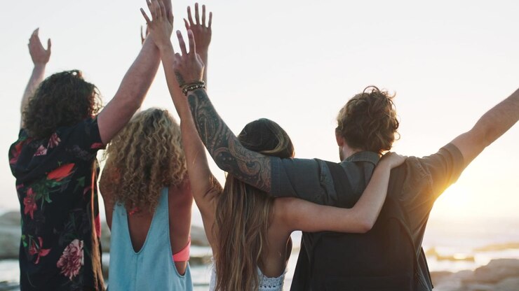 Gruppo di Amici in Piedi Insieme sulla Spiaggia al Tramonto