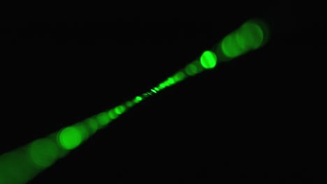 rayo láser verde sobre un fondo negro. rayo láser de potencia que brilla en la niebla