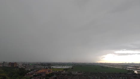 Lapso-De-Tiempo-De-Día-Lluvioso,-Cielo-Nublado,-Relámpagos-Sobre-La-Vista-De-La-Ciudad-Y-El-Prado-Verde