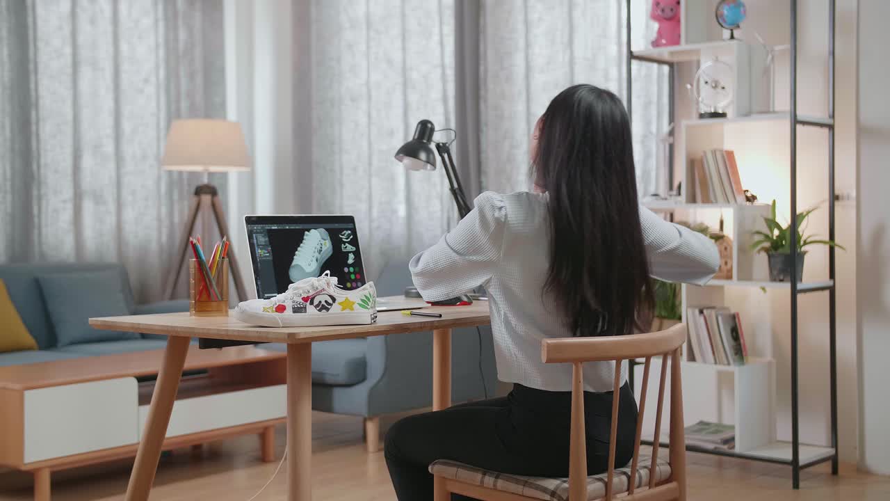 여성이 노트북에서 맞춤형 스니커를 디자인하고 있습니다.