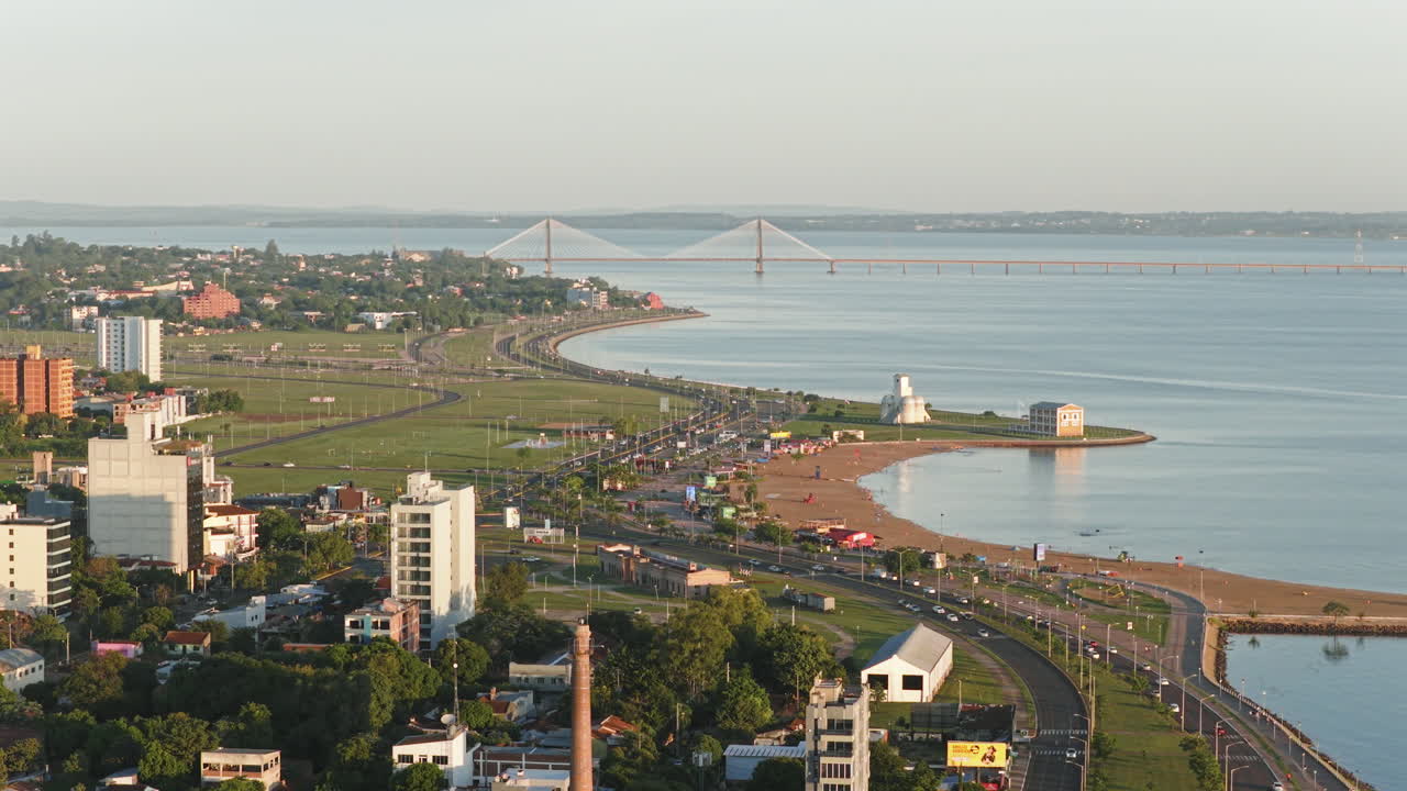 Aerial view of Encarnación, Itapúa Department, Paraguay, featuring the coastal avenue, San José beach, and the International Bridge over the Paraná River.