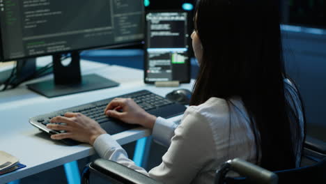 person with paraplegia working in inclusive server hub workspace, typing on pc