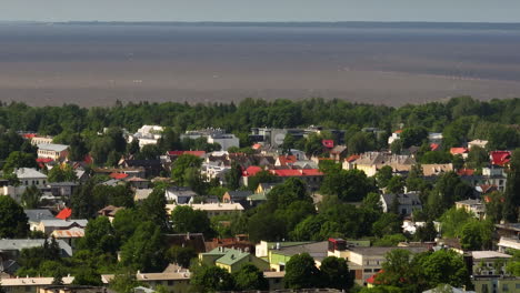 telephoto drone shot of the cityscape and the sea, sunny day in parnu, estonia