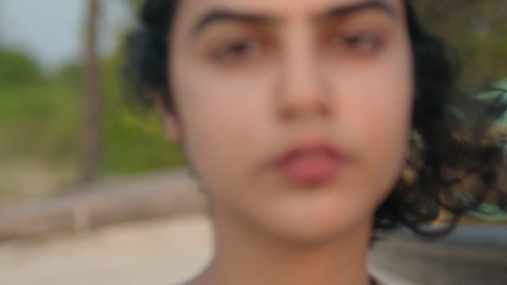 Focusing Portrait of a Girl with Black Hair in the Wind, Piercing and Direct Gaze
