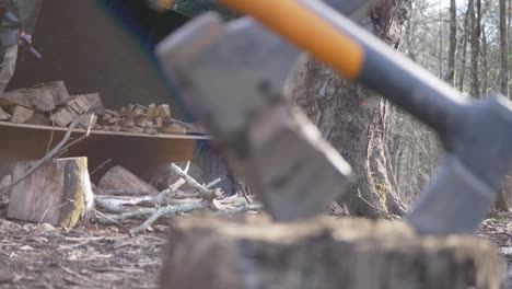 camp fire wood axes sunlight flare slow motion hand held