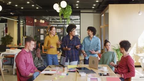 Happy-diverse-business-people-discussing-work-during-meeting-at-office