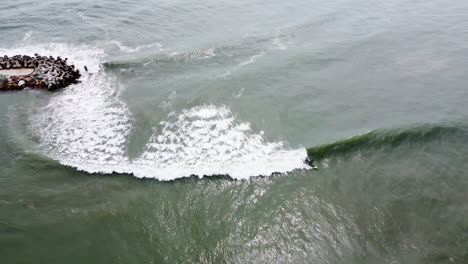 aerial tracking shot of unrecognizable surfer crashing in mid wave