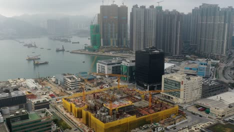 tower cranes lifting materials in a construction site in hong kong