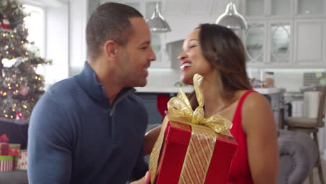 una pareja romántica intercambiando regalos de navidad filmada en r3d