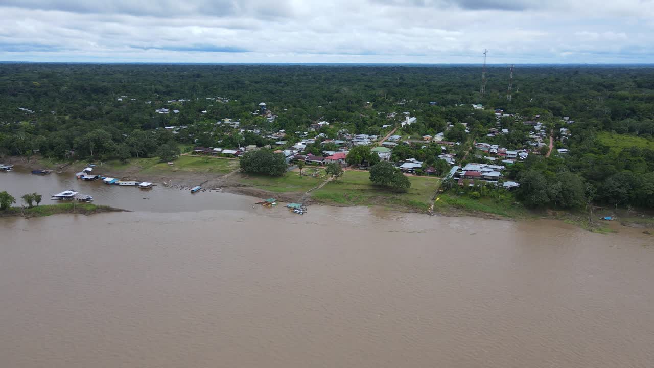 콜롬비아의 아마존 강 기슭에 있는 푸에르토 나리노에 접근하는 공중 전망, 백그라운드에서 아마존 숲