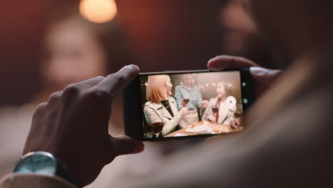 Nahaufnahme-Eines-Mannes,-Der-Sein-Smartphone-Benutzt-Und-Ein-Foto-Von-Freunden-Macht,-Die-Feiern,-Toast-Machen,-Feierparty-In-Sozialen-Medien-Teilen-Und-Dabei-Genießen,-Erinnerungen-Zu-Sammeln