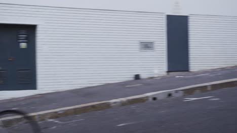 caucasian male smiling and riding his bike in a street