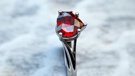 silver ring featuring a heart shaped red gemstone resting on a luxurious marble surface, symbolizing love, romance, commitment, and the elegance of fine jewelry