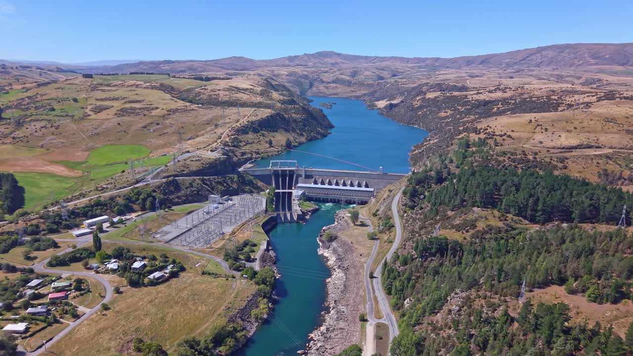 Dynamic drone footage racing toward the Roxburgh Dam on New Zealand’s Clutha River, highlighting the hydroelectric infrastructure and surrounding landscape