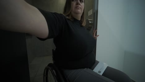 una mujer en silla de ruedas utiliza un baño público accesible, destacando la importancia del diseño inclusivo y la accesibilidad en las instalaciones cotidianas. la escena hace hincapié en la independencia y la infraestructura moderna.
