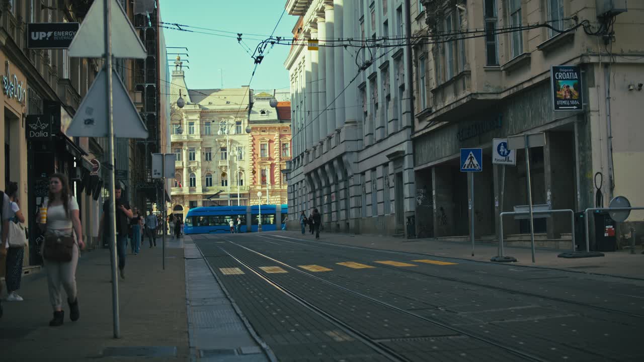 quiet street near Josip Jelačić Square in Zagreb with pedestrians and tram tracks under a bright sky