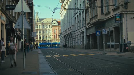 quiet street near josip jelačić square in zagreb with pedestrians and tram tracks under a bright sky