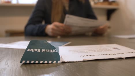 shot of a woman reading over an official ballot in the comfort of her own home