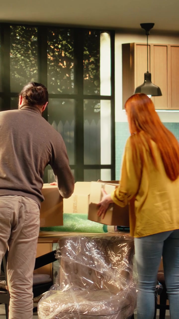 Vertical Video Young couple carrying belongings into first home on relocation day