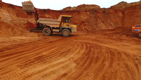 camión volqueteador en la mina de arena. vista de avión no tripulado del camión de minería trabajando en la cantera de arena