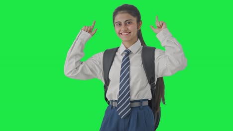 chica de la escuela india feliz bailando y disfrutando de la pantalla verde