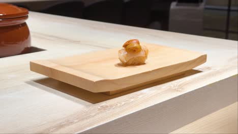 chef places sushi on wooden board