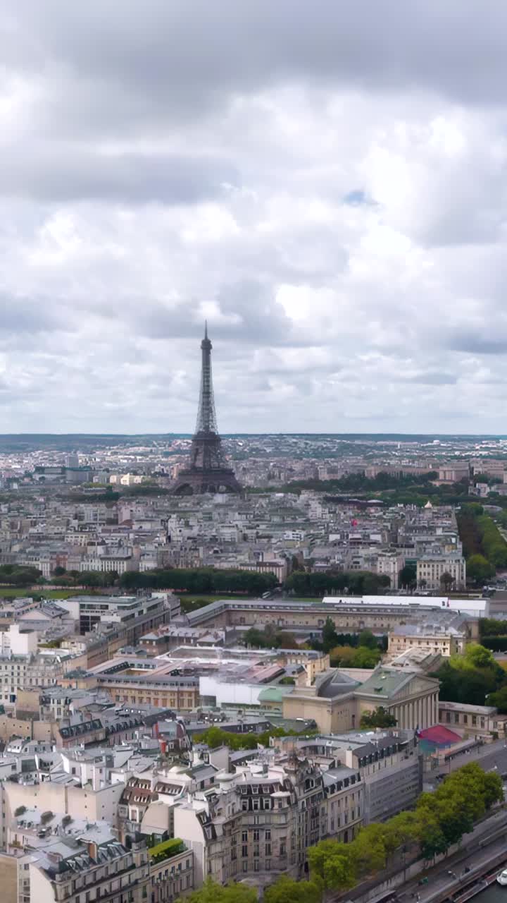 Una spettacolare ripresa aerea verticale con drone cattura la Torre Eiffel che si erge su Parigi con la Senna che si snoda attraverso lo skyline storico della città.