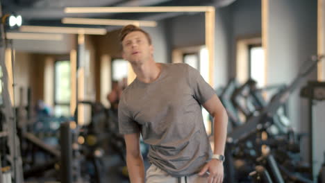 Serious-fitness-man-warming-up-in-sport-club.-Sportsman-doing-exercises-at-gym