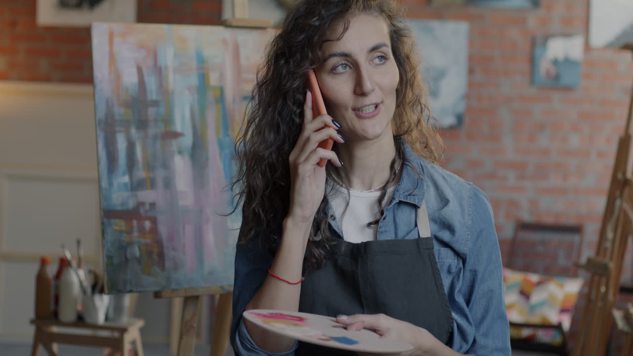 Artista donna che parla al telefono in studio