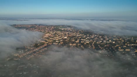 Punto-De-Vista-De-Drones-Aéreos-Cinematográficos-Paisaje-Urbano-Del-Reino-Unido-Durante-El-Amanecer,-Paisaje-Matutino-Temprano,-Tejados-De-Edificios-Residenciales-En-Niebla-Densa,-Clima-Brumoso