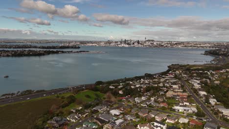 A 4K 60fps aerial shot showcasing the residential suburb of Northcote on Auckland's North Shore, bordering the tranquil waters of Shoal Bay. Perfect for real estate or lifestyle themes about NZ