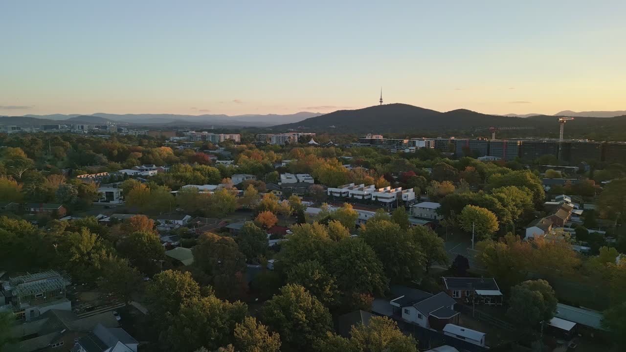 A unique drone angle highlights the sunset over Canberra’s colorful suburbs and iconic skyline in autumn.
