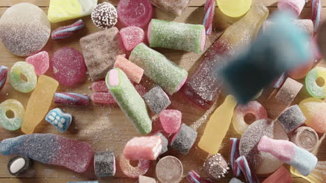 top pov as colorful sugar coated candies rain down onto table in slow motion